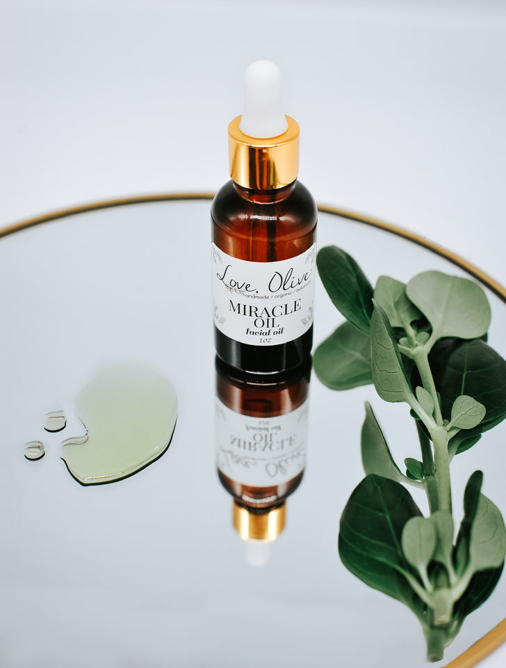 Miracle oil 1 ounce sitting on a mirrored table